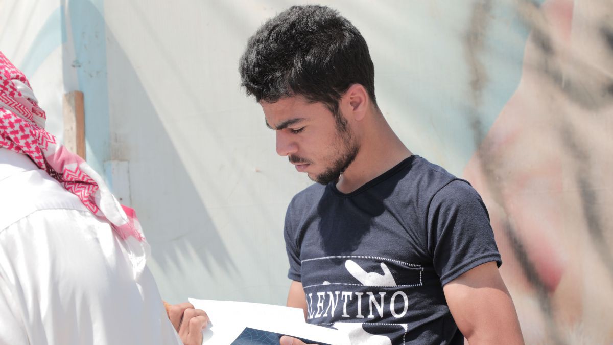 Jugendlicher in schwarzem T-Shirt liest eine Bibel.