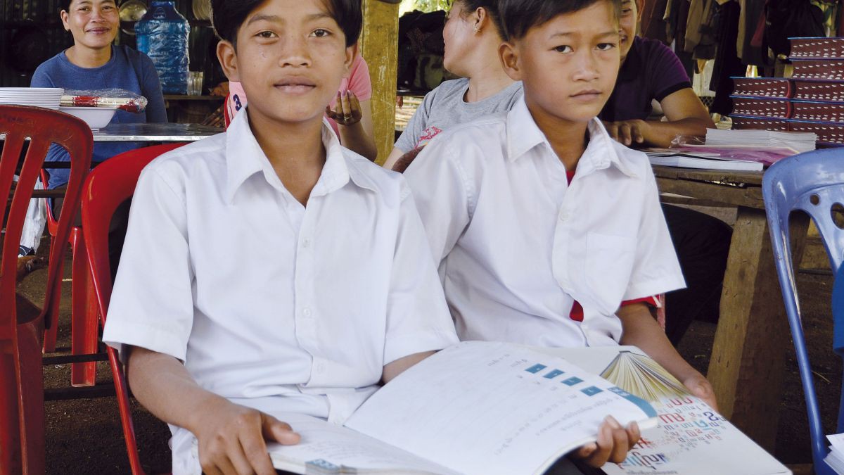 Zwei Buben sitzen mit ihren Lernunterlagen in der Schule.