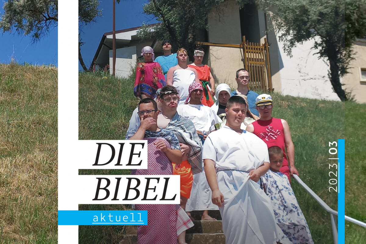 Das aktuelle Cover des Magazins "die Bibel Aktuell" eingebettet in das Foto aus dem das Coverbild geschnitten wurde. Man sieht eine Schar junger Menschen mit Down-Syndrom verkleidet als Figuren aus biblischer Zeit.