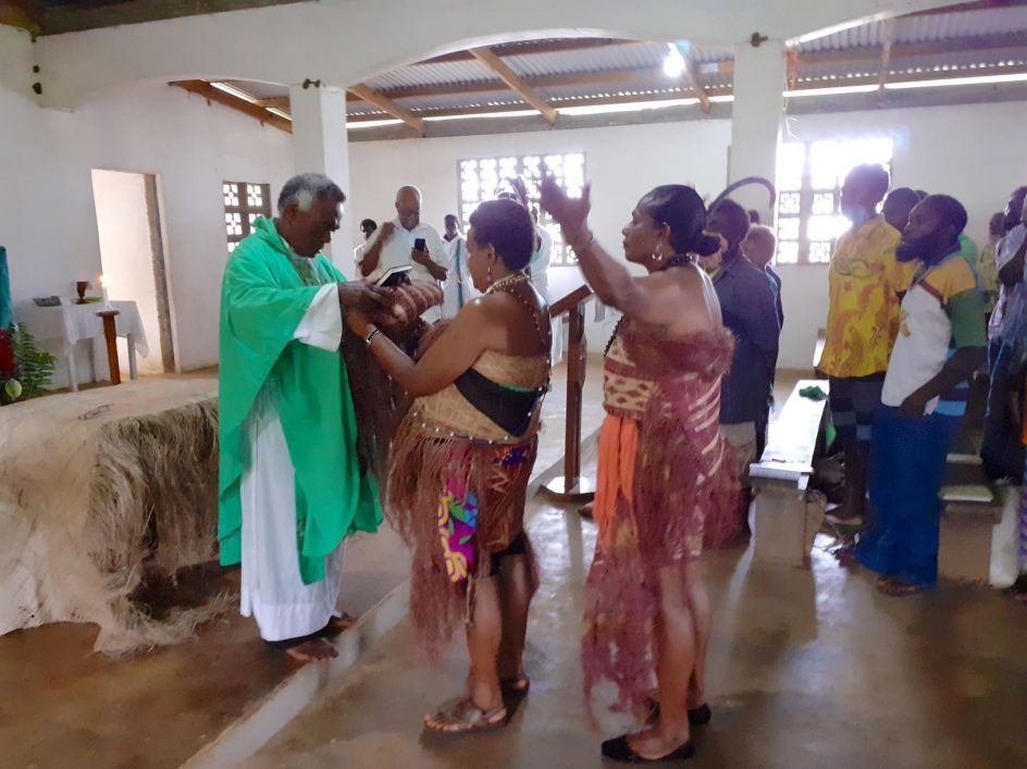 Übergabe des Neuen Testaments in Hano während eines Gottesdienstes. 