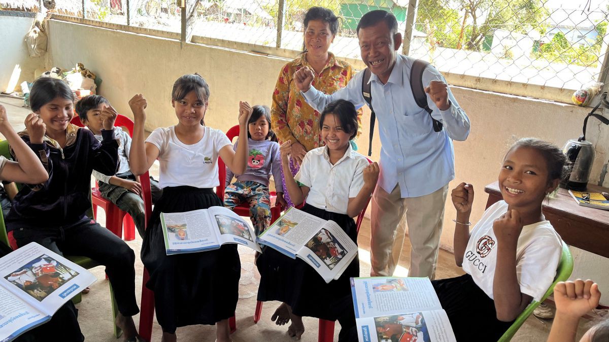 Pastor Kang Seia und seine jungen Schüler freuen sich über die Lernunterlagen