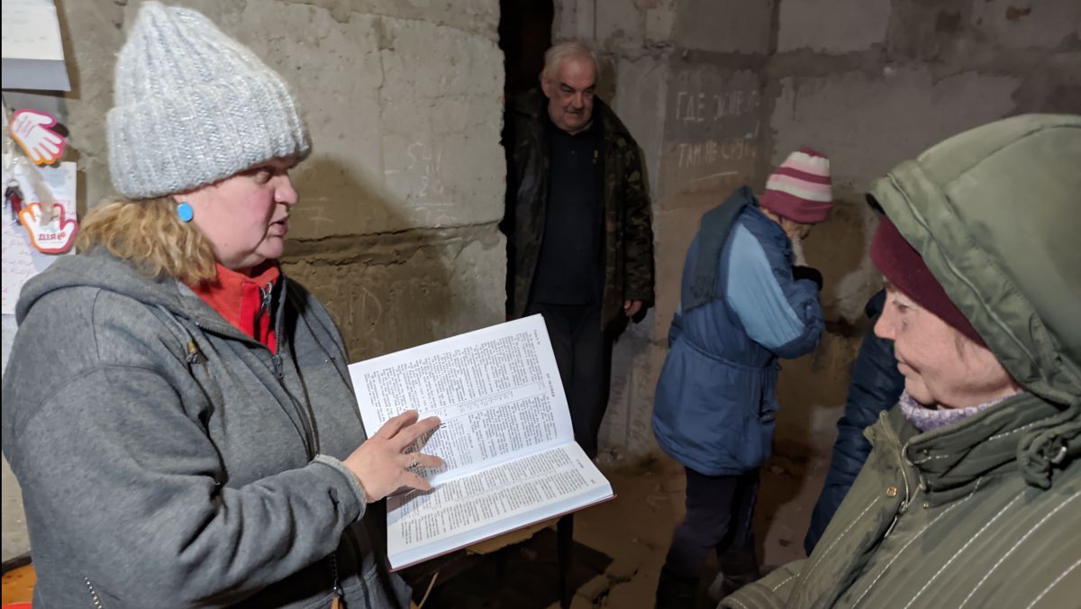 Ukrainische Menschen im Luftschutzbunker lesen in der Bibel. Ukrainische Menschen im Luftschutzbunker