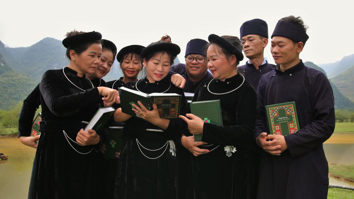 Menschen in der traditionellen Kleidung der Tay lesen gemeinsam in der Bibel