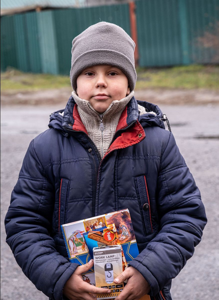 Viele Menschen bitten um eine Bibel, die zuvor kein Interesse daran hatten. Die Kinderbibeln sind sowohl bei den Kindern als auch bei den Erwachsenen sehr gefragt. Denn die Kinderbibeln sind leichter zu lesen, wenn die Konzentration nachlässt. Ein Junge hält eine ukrainische Kinderbibel und ein batteriebetriebenes Licht in der Hand.