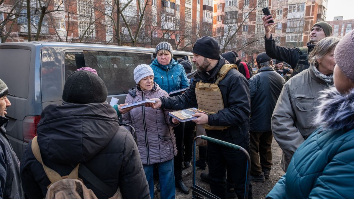 "Bitte schön! Möge Gott eure Herzen trösten! Dies ist das heilige Evangelium. Bitte lesen Sie es!“ Viele strecken ihre Hände aus um eine Bibel zu bekommen, wenn Anatoliy die Kisten mit Bibeln herausnimmt. Anatoly steht umringt von Menschen und verteilt Bibeln in der Ukraine