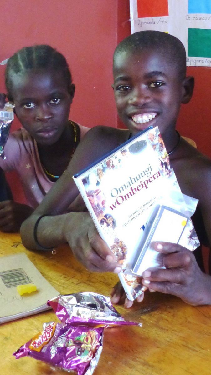 Zu sehen sind zwei junge Menschen. Auf der linken Seite präsentiert der junge Josef ganz stolz seine neue Kinderbibel.