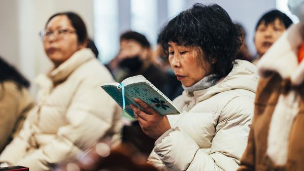 Eine chinesische Dame die in der Bibel liest.