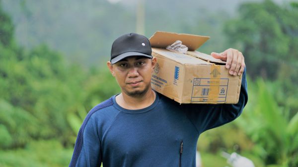 Ein Mann schleppt einen Karton mit Bibeln, der zur Verbreitung in Kaltara in der Provinz Nordkalimantan bestimmt ist.