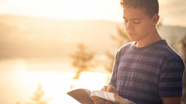 Junger Mann mit Bibel in der Hand